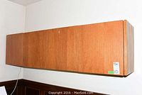 Wall-mounted wooden hanging cabinet with two doors and rectangular shape.