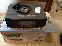 Front and top view of the Cambridge Soundworks 88CD stereo system sitting on its original box, showing controls and cables on top.