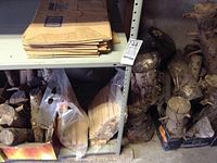 Shelf with two boxes of dry firewood logs and some paper bags on top