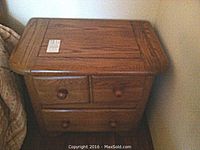 Photo of first solid oak end table with all drawers closed, showing the wood grain finish and drawer knobs