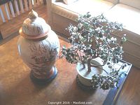 View of the Andrea by Sadek ginger jar and faux bonsai tree side by side on a wooden table