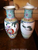 Pair of two Chinese porcelain vases with detailed hand-painted figural and floral motifs, displayed on a table.