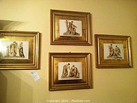 Four convex glass framed prints depicting ancient classical figural scenes, hung on wall.
