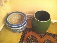 Both ceramic planters side by side on carpeted floor showing size difference and finishes.