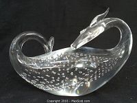 Front view of Steuben glass dragon paperweight with bubble inclusions on black background