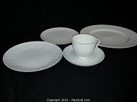 Group view showing plates, cup and saucer on black background