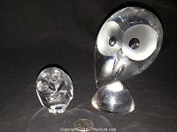 Overview of both Steuben owl figurines on black background