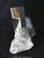 Clear Steuben glass crystal sculpture on black background viewed from front.