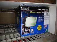 Regent dusk to dawn mercury vapor floodlight packaging showing 80 watt bulb included, bronze finish, automatic on/off at dusk and dawn, lights up to 7,000 square feet.