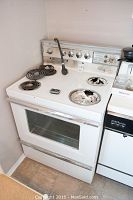 Vintage Westinghouse 30 inch electric stove front view with four coil burners, one severely damaged