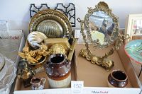 Photo shows brass trays, ornate brass mirror on stand, brass cherub figurines, ceramic vases and decorative egg-shaped porcelain item, along with other small decorative items.