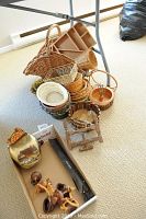 Photo showing a variety of wicker baskets grouped together, stacked and nestled, along with nut bowls and a boxed black plastic recorder