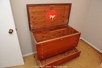 Open cedar lined chest dresser showing interior cedar wood and mounted red decorative horse plaque inside lid