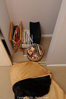 Long fur coat partially inside a garment bag, with several containers holding sewing accessories placed nearby on the floor in a corner.