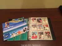 Open binder showing multiple hockey cards inside plastic protectors, with a 'Stay & Play' booklet on top.
