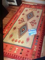 Full view of the 5x8 rug laid on wooden floor showing its overall pattern and colors.