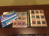 Photo showing part of the Yo-Gi-Oh collector card binder with cards in plastic sleeves and additional inserts.