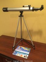 Full view of the Vivitar telescope mounted on tripod with the instruction manual on the table.