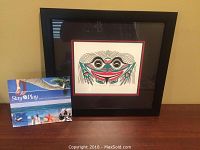 Framed Native art print by Patrick Amos on a table next to a 'Stay & Play' brochure.