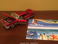 Red diecast Cadillac model car showing open hood, doors, and trunk with detailed engine and interior.