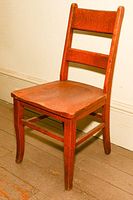 Photo of a solid wood old-fashioned chair with two horizontal slats on the backrest and reddish-brown finish. The wood shows signs of wear and aging, but the chair remains sturdy.