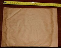 Single padded mailing envelope laid out flat with measuring tape showing width approximately 12 inches.