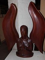 Front view of the praying angel wood carving showing full figure with wings spread vertically.