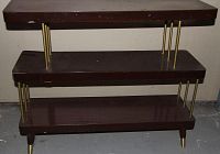 Full view of brown arborite bookshelf showing three shelves with gold-tone metal rods and capped legs.