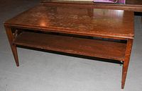 Front and side view of wood coffee table showing rectangular top and lower shelf supported by X-shaped wooden cross braces on each side.