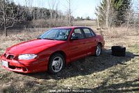 Front three-quarter view showing passenger side and extra tires on ground