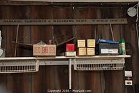 Wooden railway sign and model railroad parts on shelf showing 'Napanee, Tamworth & Maelbank RLWY. S Scale''