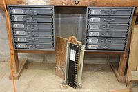 Both gray Brafasco organizers mounted under wooden bench, each with six labeled drawers