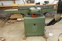 Front view of jointer showing infeed/outfeed tables, fence and cabinet base