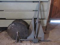 Metal anchor and 15 inch diameter metal anchor reel on stand displayed on a floor surface.
