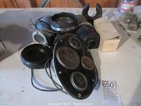 Overview of multiple marine dashboard and lighting components shown on a table including various gauges and lights.