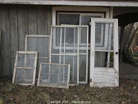 Photo of all windows and the door arranged against outdoor wall. Shows all items and general condition.