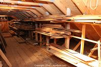 Overview of loft shelves stocked with assorted hardwood and softwood boards