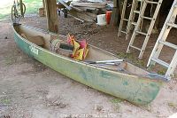 Full view of entire canoe and accessories under shelter