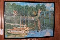 Framed Monet style print depicting water scene with sailboats and trees