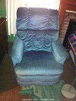 Blue Lazy Boy recliner chair with visible padded armrests and backrest, showing lightly used fabric upholstery.