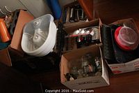 Five boxes of household essentials including Conair foot bath, glass jars, pest repellent units, cookbooks and plastic lids.