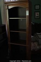 Photo of the full tall wood bookshelf with three shelves, brown wood finish and decorative top molding.