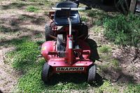 Front view of red Snapper HiVac riding mower, dual front wheels, ‘SNAPPER’ logo on deck, black vinyl seat visible