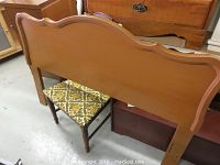 Full view of painted wooden headboard showing brown finish and pink trim in a gently curved top design.