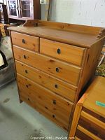 Front angle of IKEA pine dresser showing five drawers with metal handles and natural pine finish.