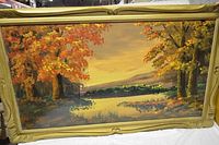 Full view of the framed autumn landscape oil painting showing vibrant foliage and reflective water.