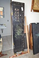 Single folded panel showing black lacquer finish with bamboo motif and Chinese characters.