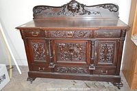 Front view of carved wooden sideboard with crest back