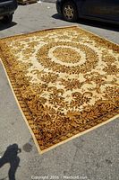 Full view of the rectangular rug laid out on pavement showing its overall floral pattern and size.