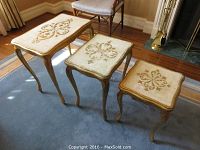 Three nested gilt wood tables shown together on carpet